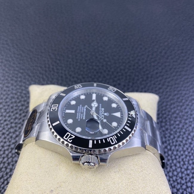 Clean factory top replica Rolex men's watch, black dial, steel strap, black Submariner, automatic movement, side view.